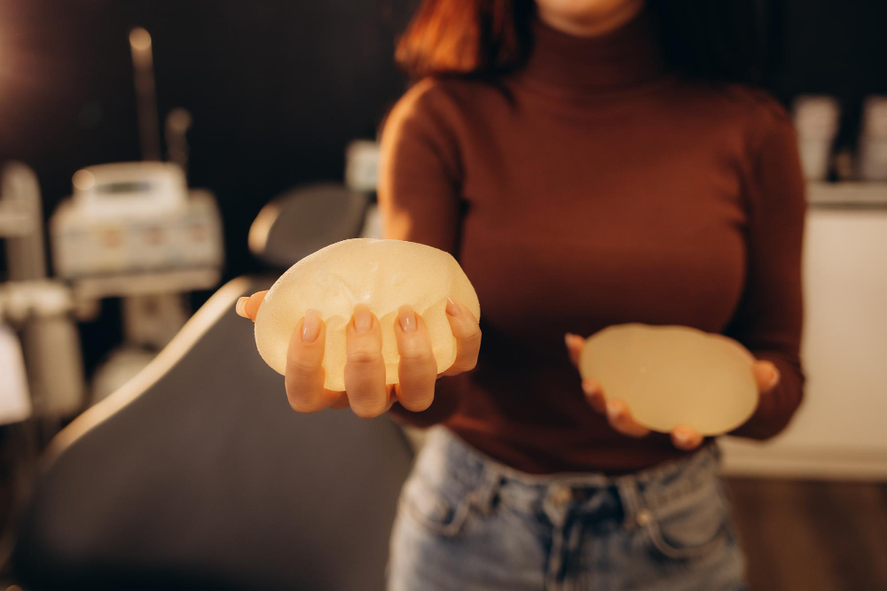 recambio de prótesis mamarias, mujer sosteniendo dos prótesis en las manos